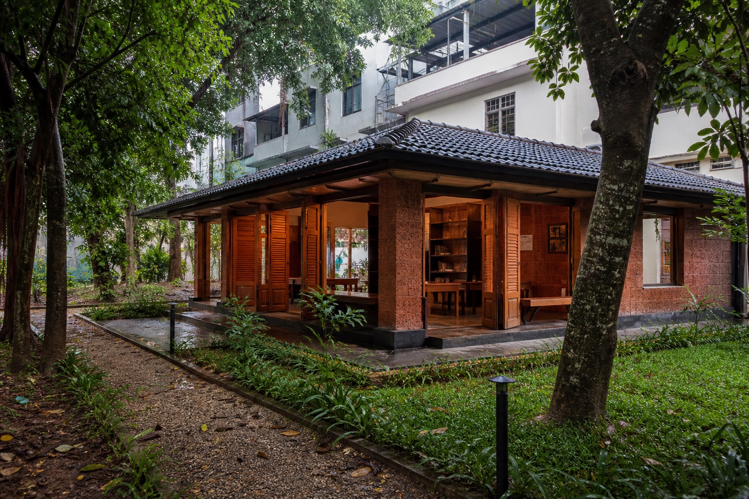 A shaded laterite reading room opens to a small public garden